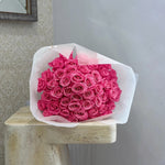 Fuchsia rose bouquet wrapped in white paper