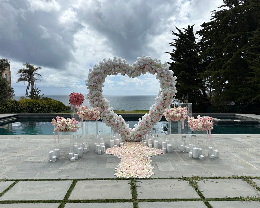 Decorative heart-shaped floral arrangement by a pool with ocean view floral design by AY Flowers